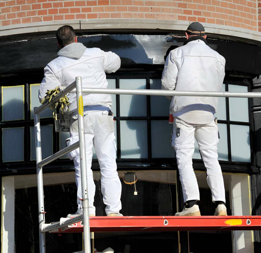 Professional painters from Harris Painting Co. working on an exterior wall, showcasing our expert painting services in Pensacola.